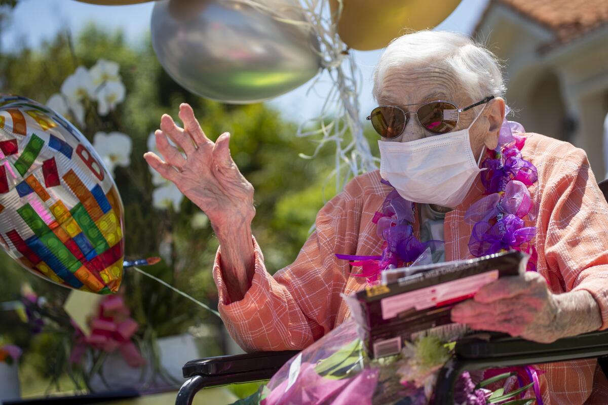 Mildred Stratton waves to a caravan of cars led by the Alhambra police and fire departments parading past her home, celebrating her 102nd birthday on May 20 in Alhambra.