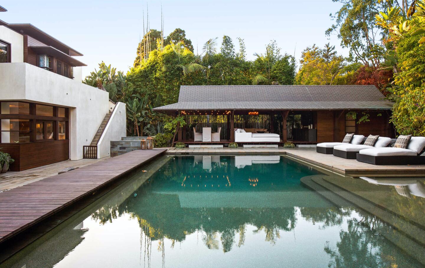 The pool surrounded by a deck and lounge chairs.