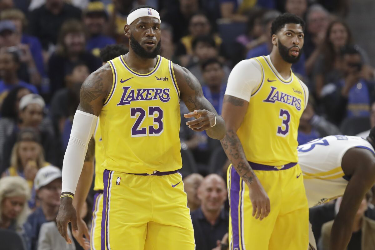 LeBron James, left, plays with new Lakers teammate Anthony Davis during a preseason game against the Golden State Warriors on Saturday in San Francisco.