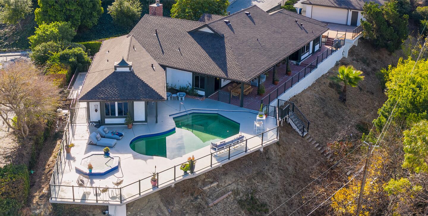 An aerial view of the spa, pool and the hill the home is perched on.