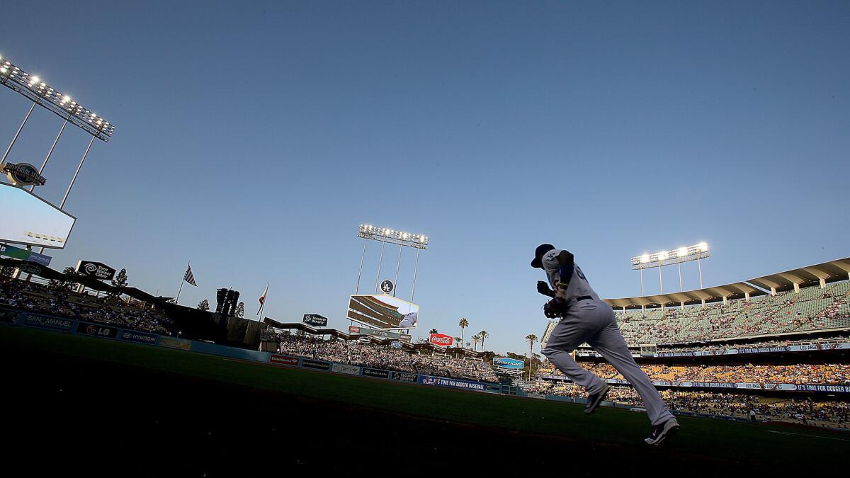 Dodgers center fielder Yasiel Puig runs onto the field at Dodger Stadium before a game against the St. Louis Cardinals in June.