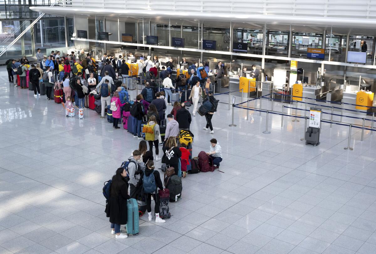 Passengers wait at a Lufthansa check-in counter at Munich Airport, Germany, Thursday March 7. 2024. The Verdi trade union is paralyzing important parts of German air traffic on Thursday and Friday with renewed warning strikes by several professional groups. (Sven Hoppe/dpa via AP)