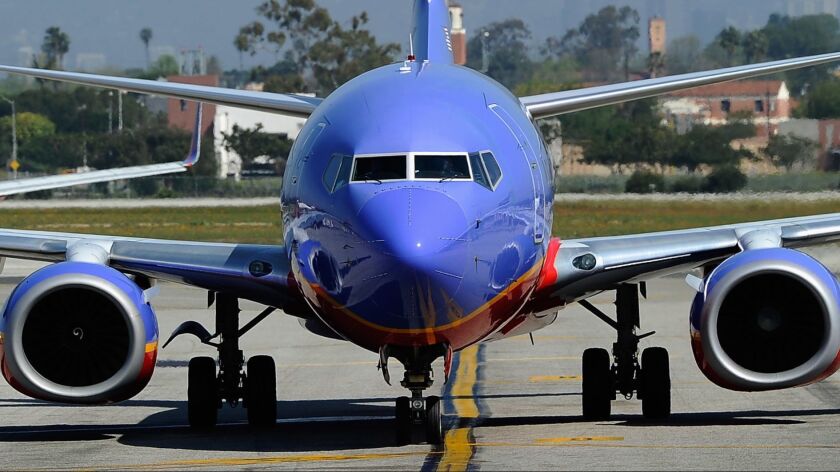 A Southwest Airlines Boeing 737-700 passenger jet taxis on the tarmac after arriving at Los Angeles International Airport. The airline says the partial government shutdown is delaying the start of service to Hawaii.