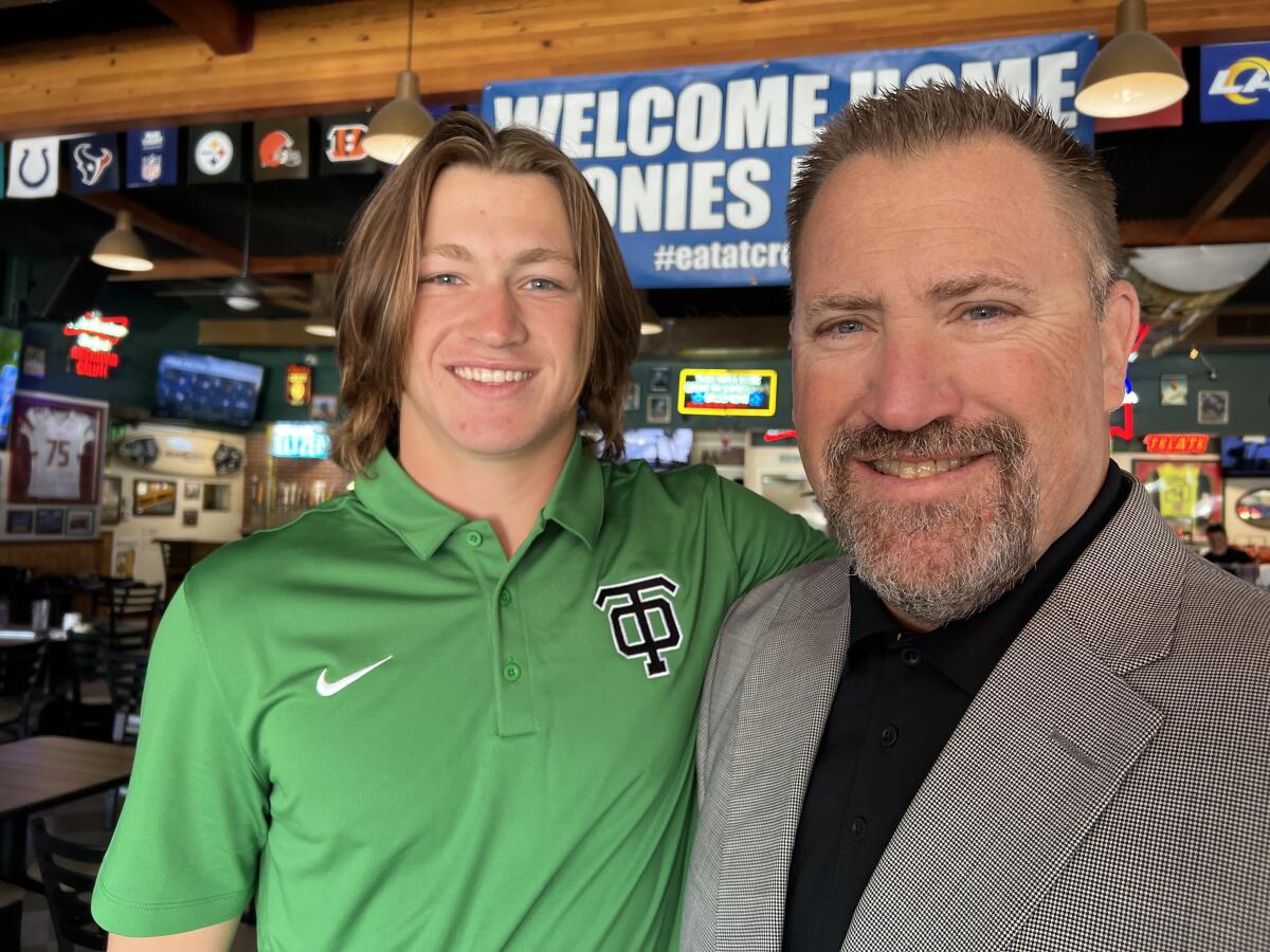 Junior linebacker Cory McEnroe, left, poses for a photo with his father, Thousand Oaks High football coach Ben McEnroe.