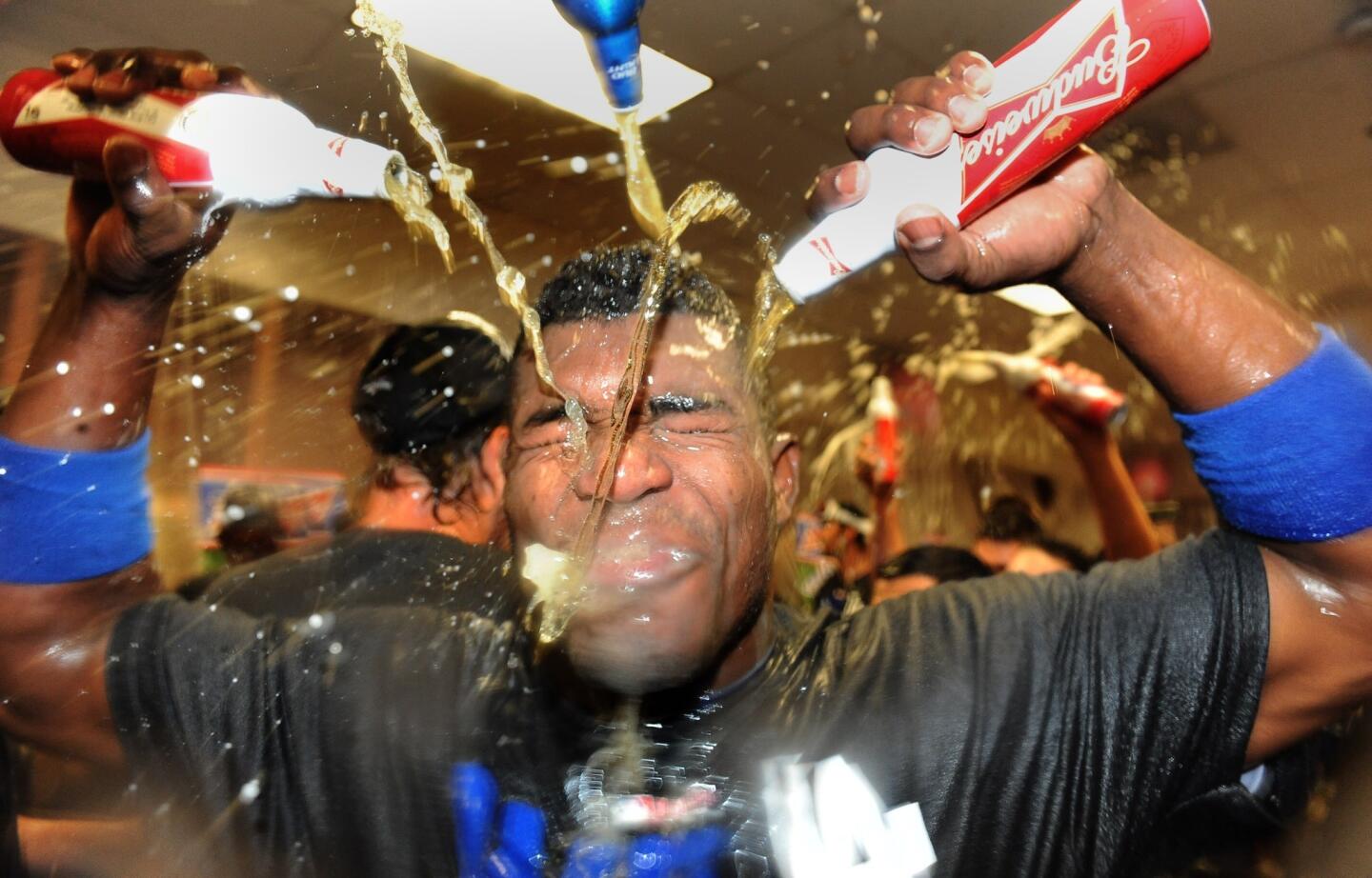 Dodgers rookie right fielder Yasiel Puig is drenched during the team's clubhouse celebration following their 7-6 victory over the Arizona Diamondbacks that clinched a playoff spot.