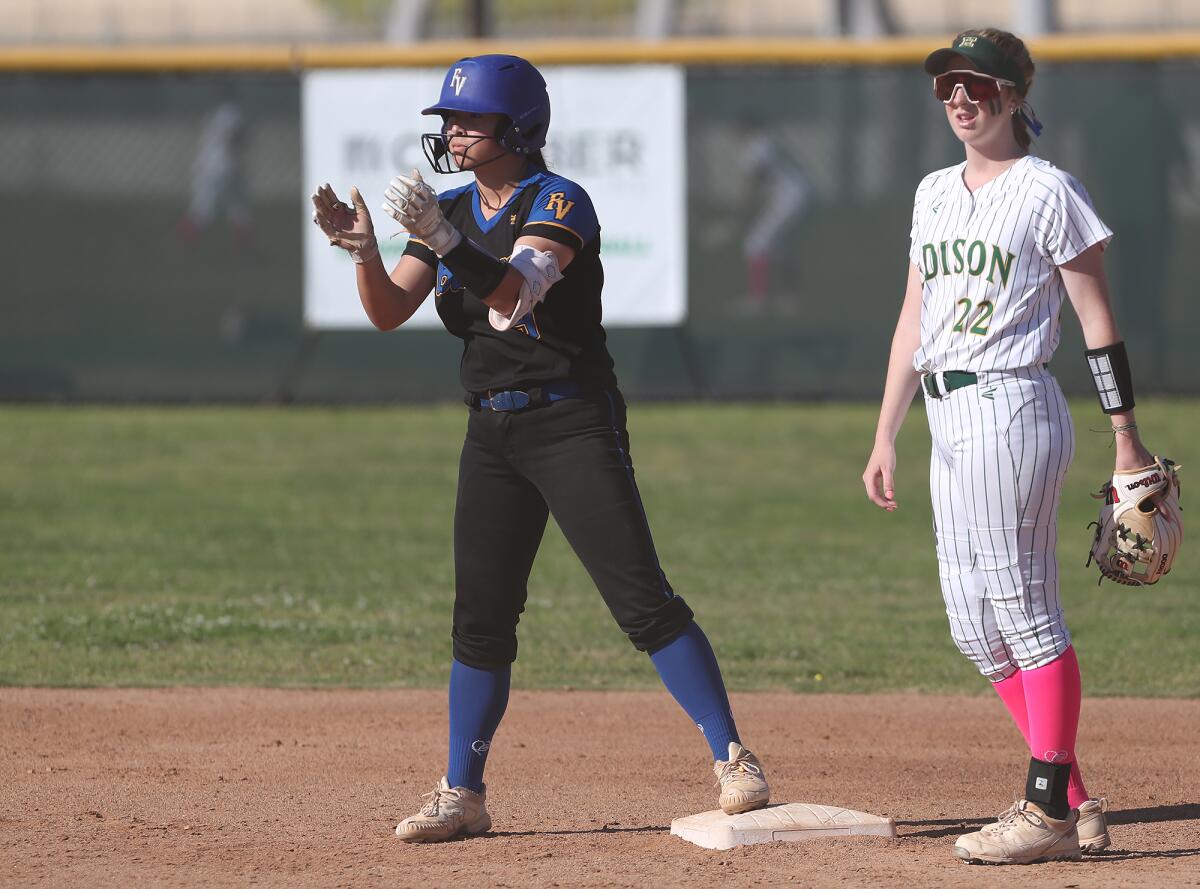 Fountain Valley's Ella Kim (9) claps toward the dugout as she stands on second base with a two-run double against Edison.