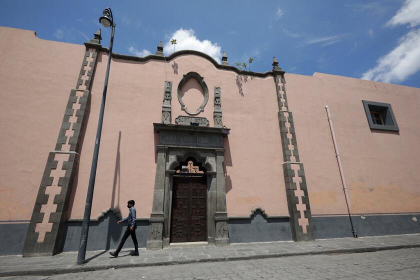 Un hombre camina por la entrada del exconvento de Santa Rosa en Puebla