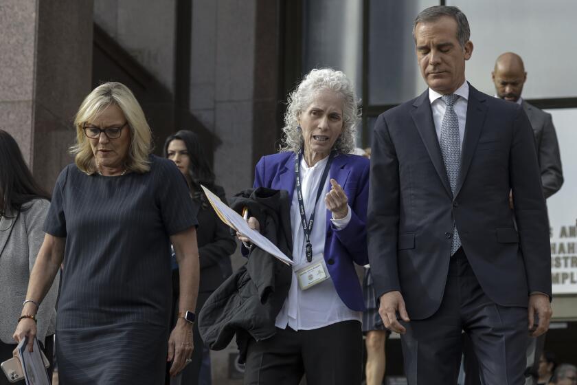 LOS ANGELES, CA - MARCH 04 , 2020 - L.A. County Supervisor Kathryn Barger, left, L.A. County Department of Public Health Director Barbara Ferrer, and Los Angeles Mayor Eric Garcetti walk down the steps at Kenneth Hahn Hall of Administration to address a press conference to declare a health emergency as the number of coronavirus cases increased to seven, with six new cases in Los Angeles County. None of the new cases are connected to "community spread," officials said. All individuals were exposed to COVID-19 through close contacts. The additional cases were confirmed Tuesday night. Officials said three of the new cases were travelers who had visited northern Italy, two were family members who had close contact with someone outside of the county who was infected, and one had a job that put them in contact with travelers. One person has been hospitalized, and the others are isolated at home. (Irfan Khan / Los Angeles Times)