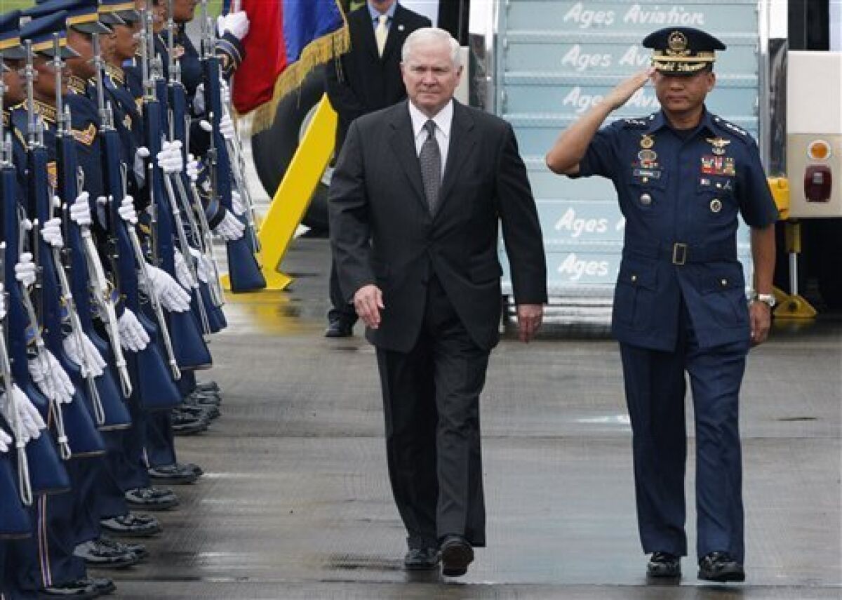 U.S. Defense Secretary Robert Gates, center, is escorted by Philippine Air Force Commanding General Lt. Gen. Oscar Ravena upon his arrival Monday, June 1, 2009, in Manila, Philippines. Gates is in the Philippines on a one day visit to discuss bilateral issues concerning security and counter-terrorism. (AP Photo/ Joseph Agcaoili)