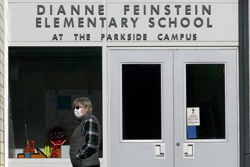 A pedestrian walks below a sign for Dianne Feinstein Elementary School in San Francisco, on Dec. 17, 2020. The San Francisco school board has voted to remove the names of George Washington and Abraham Lincoln from public schools after officials deemed them and other prominent figures, including Sen. Dianne Feinstein unworthy of the honor. After months of controversy, the board voted 6-1 Tuesday, Jan. 26, 2021, in favor of renaming 44 San Francisco school sites with new names with no connection to slavery, oppression, racism or similar criteria, the San Francisco Chronicle reported. (AP Photo/Jeff Chiu)