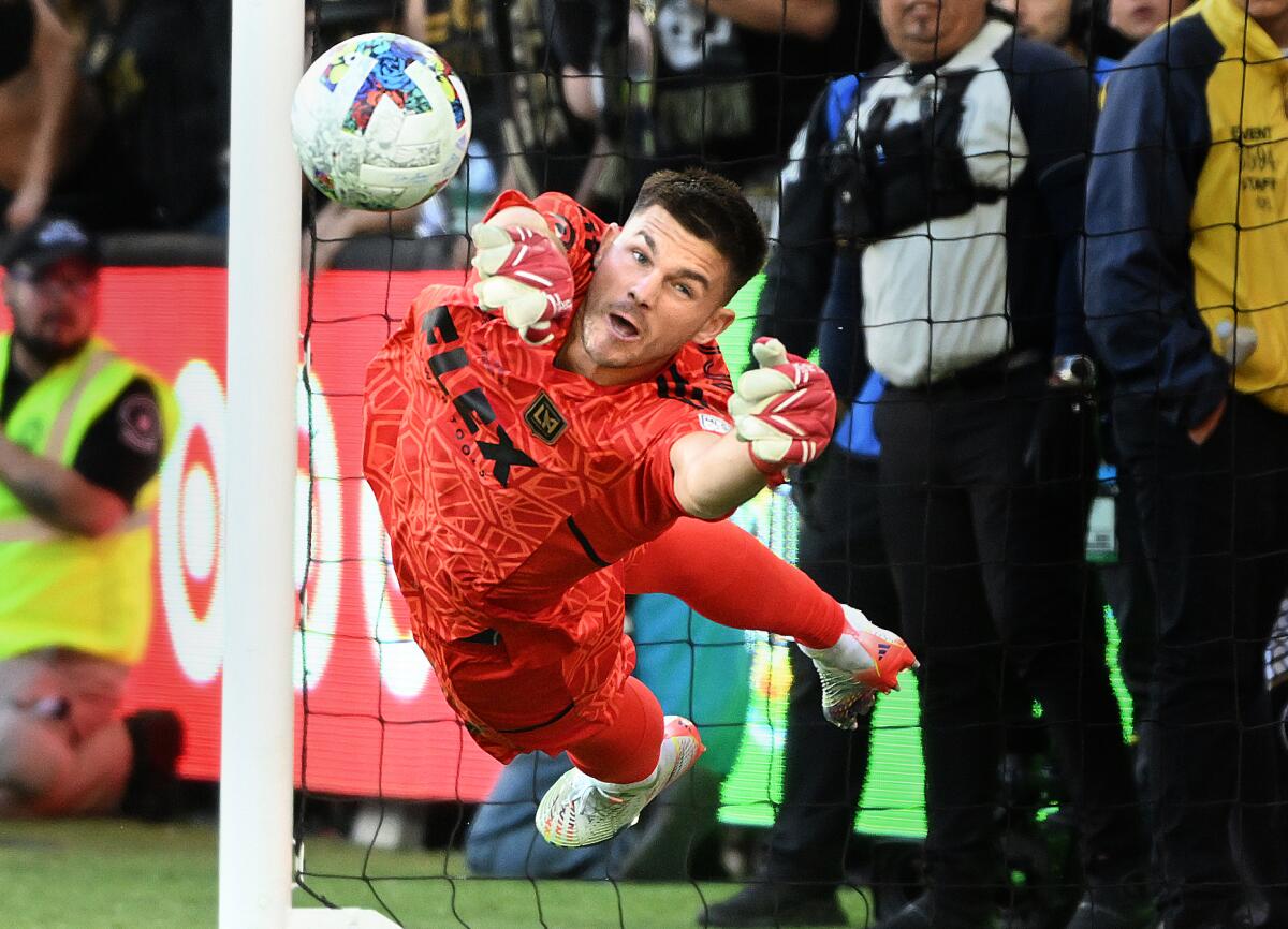 LAFC goalie John McCarthy dives to block a shot by a Philadelphia Union player.