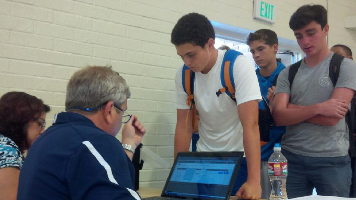 ¿Loyola athletic trainer Tim Moscicki registers students to take concussion baseline tests.