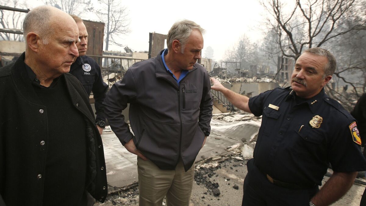 Interior Secretary Ryan Zinke, center, received a briefing from Cal FIRE Regional Chief Scott Upton, right, in fire-stricken Paradise, Calif. Gov. Jerry Brown is at left. But was Zinke listening?