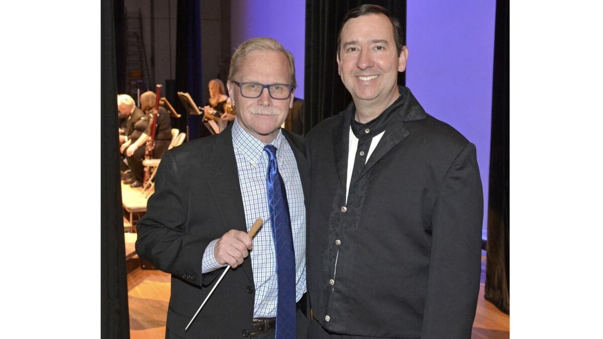 Guest conductor Los Angeles Times columnist Chris Erskine, left, getting last minute tips in the wings from assistant conductor Michael Stanley.