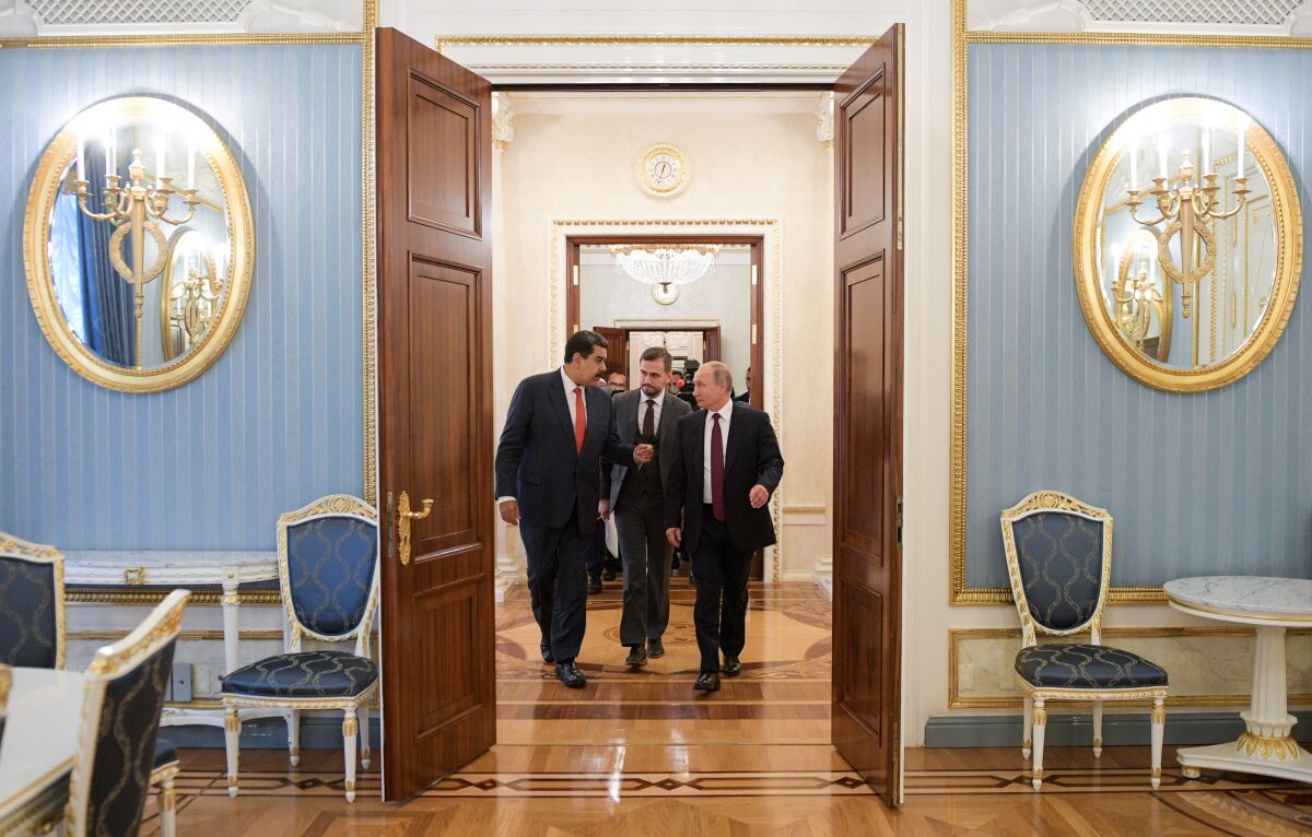 Three men walk toward an open door entering a large office