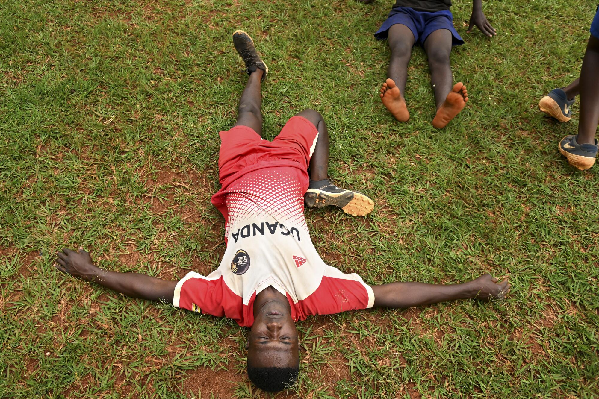 Dennis Kasumba stretches before a workout at the national field in Gayaza, Uganda.