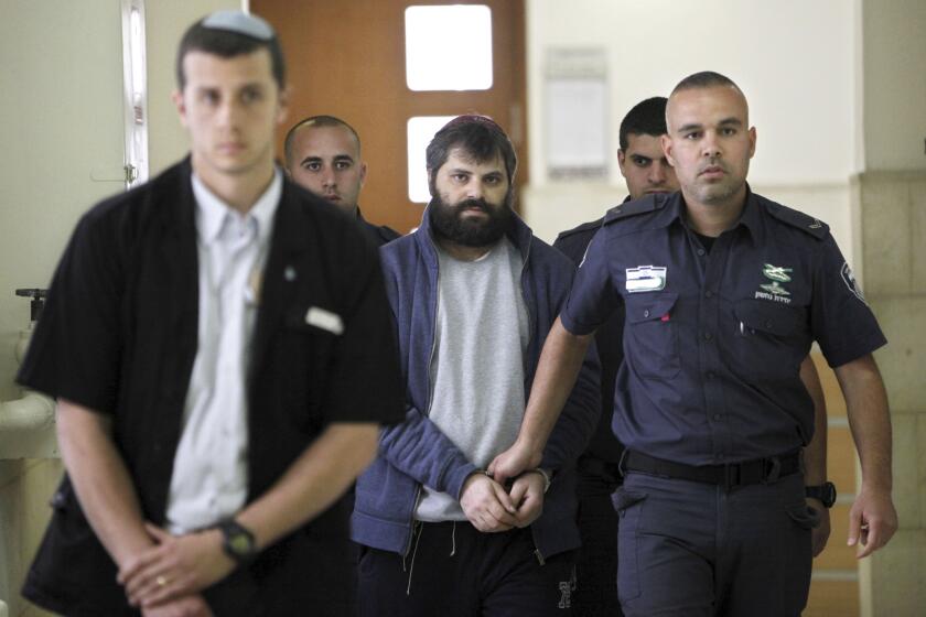 FILE - Yosef Haim Ben David, center, arrives at Jerusalem court during his murder trial in the death of a 16-year-old Palestinian boy, in Jerusalem, Tuesday, March 22, 2016. An Israeli group raising funds for Jewish radicals convicted in some of the country’s most notorious hate crimes, Including Ben David, is collecting tax-exempt donations from Americans, according to an investigation by the AP and non-profit Israeli investigative platform. That is a sign that Israel’s FAR right is gaining a new foothold in the United States. (AP Photo/Mahmoud Illean, File)