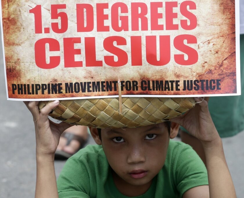 A boy holds a traditional bag with a message during a rally leading calling on Philippine President Benigno Aquino III to focus on "climate justice" when he speaks before the United Nations Climate Change Summit in the U.S. later this month.