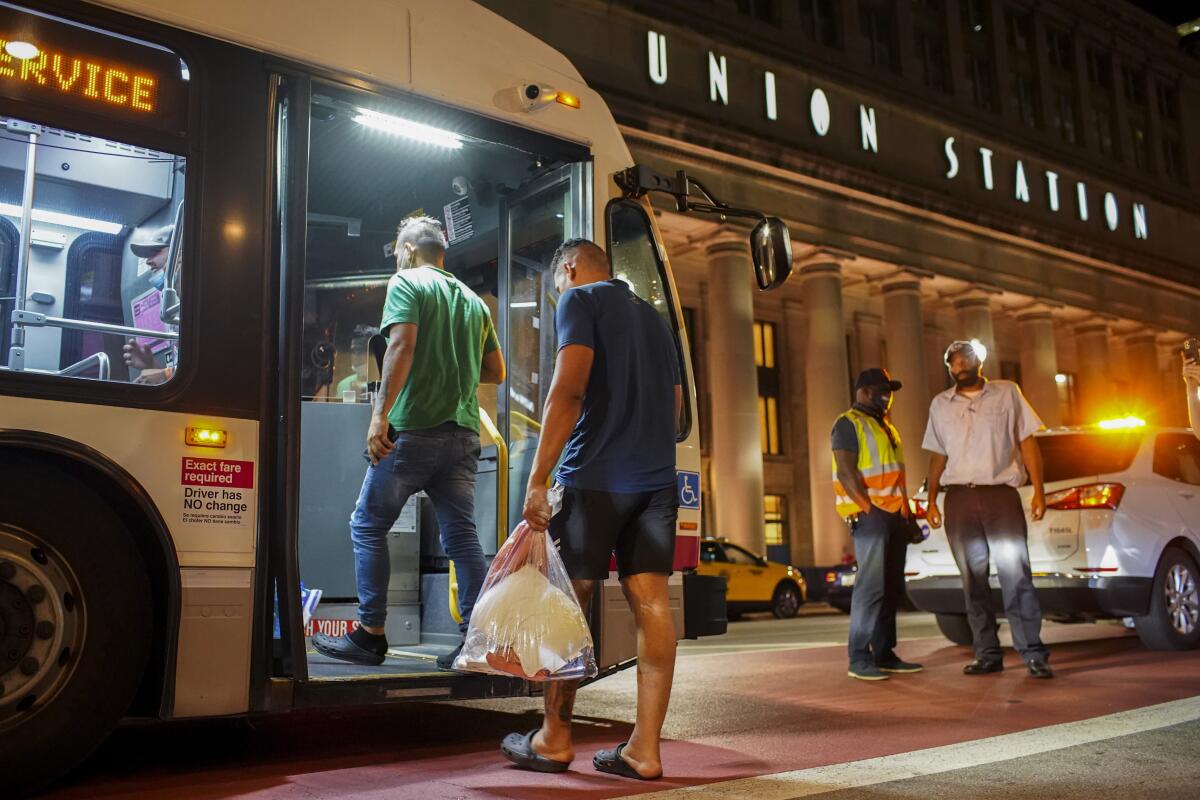 A group of people board a Chicago Transit Authority bus before being taken to a Salvation Army after arriving on a bus with other migrants from Texas at Union Station, Wednesday, Aug. 31, 2022, in Chicago. The immigrants are being bused from Texas as part of a strategy launched by TexasGov. Greg Abbott this year to share the influx of people from outside the United States with liberal cities. (Armando L. Sanchez/Chicago Tribune via AP)