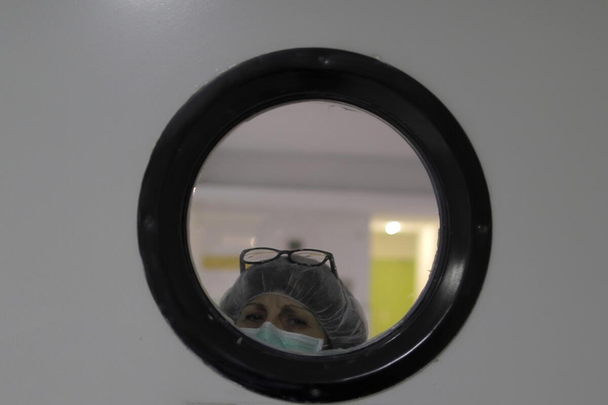 A health worker looks out of from a window at a nursing home in Madrid, Spain, on Tuesday.