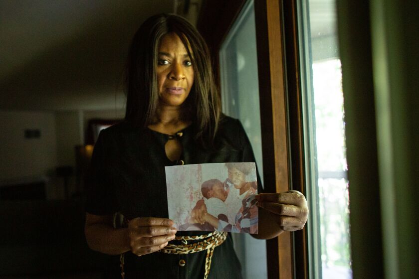 MINNEAPOLIS , MINNESOTA - JUNE 03: Angela Harrelson of Eagan, MN, aunt of Gorge Floyd poses for a portrait holding a photo Gorge Floyd as a baby being held by his late mother and Harrelson's sister, Larcenia Jones Floyd, in her living room on Wednesday, June 3, 2020 in Minneapolis , Minnesota. (Jason Armond / Los Angeles Times)