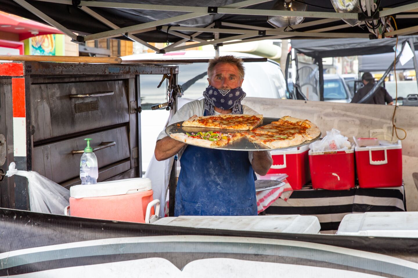 Chuck Fisher, owner of Fat Boyz Pizza, offers up some hefty slices at the Ocean Beach Farmers Market.