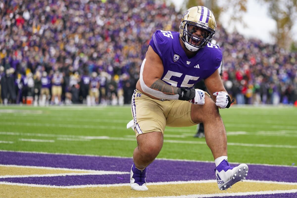 Washington offensive lineman Troy Fautanu flexes his arms and yells after a touchdown.