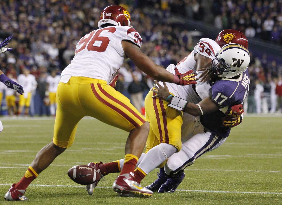 USC defensive tackle Leonard Williams forces a fumble with a hit on Washington quarterback Keith Price in 2012. The Trojans recovered at their 4-yard line and won, 24-14.