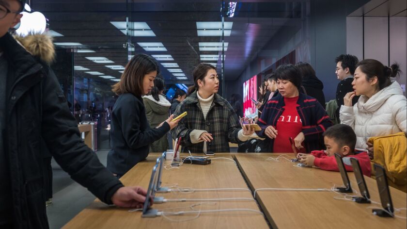 Customers browse inside an Apple store in Shenzhen, China. Apple lowered its revenue guidance this month, blaming China's slowing economy and weaker than expected iPhone sales.