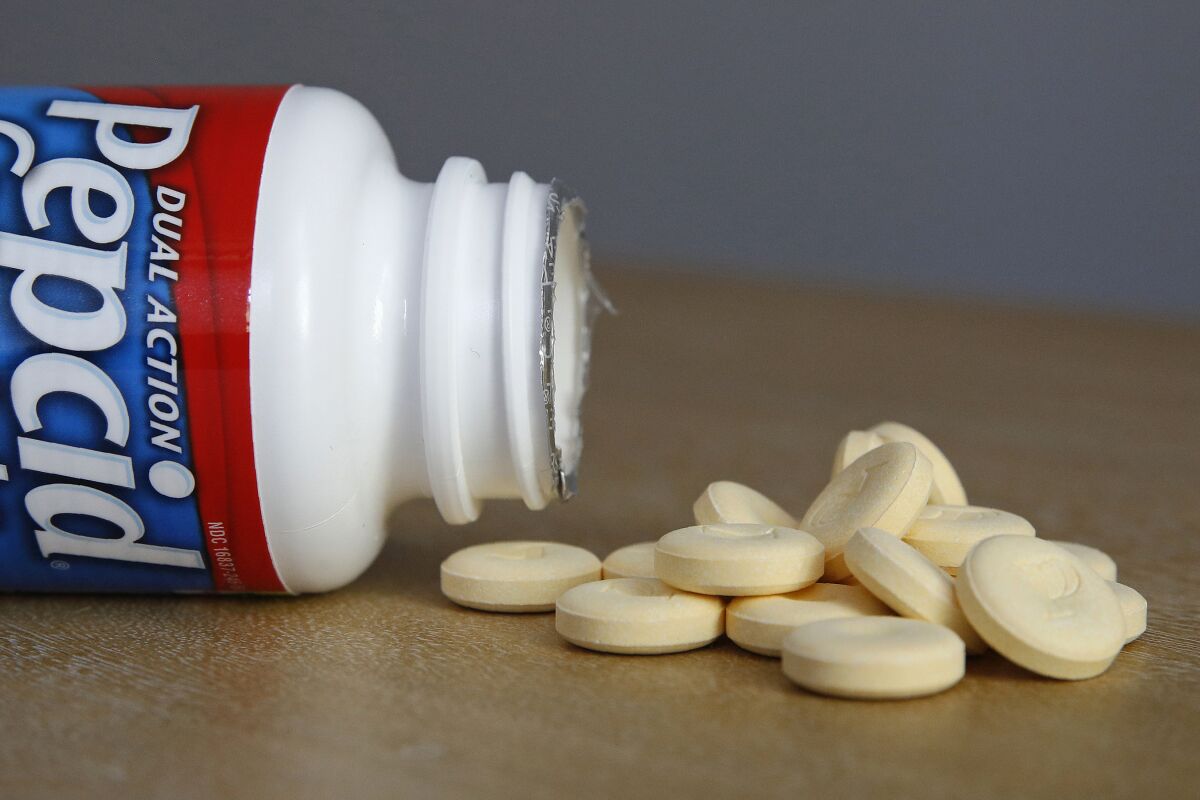 This June 15, 2020 photo shows a bottle and tablets of Pepcid antacid in Washington. The U.S. government's Pepcid project has revealed what critics describe as the Trump administration’s disregard for science and anti-corruption rules meant to guard against taxpayer dollars going to political cronies or funding projects that aren’t rigorously designed. (AP Photo/Patrick Semansky)