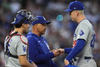 Los Angeles Dodgers manager Dave Roberts, center, takes the ball from starting pitcher.