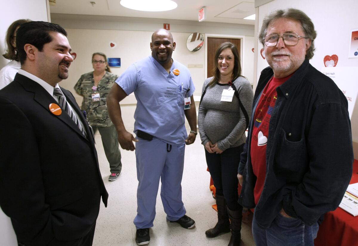 Rudy Donofrio, 66 of Glendale, right, got a chance to meet hospital employees and locals who helped saved his life about 6 months ago when he was having a heart attack in front of the hospital -- Howard Ferguson, left, and Michelle Carmichael, right -- during the Kings and Queens of Heart celebration at Glendale Memorial Hospital in Glendale on Thursday, Feb. 20, 2014.