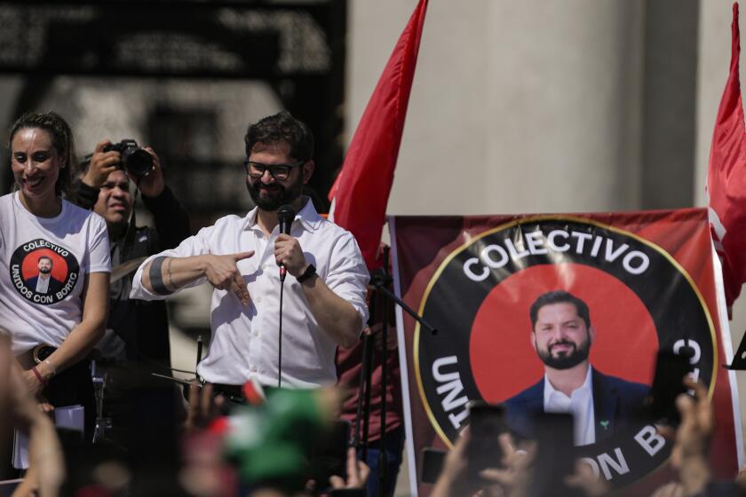 El presidente de Chile, Gabriel Boric, hace gestos con sus partidarios durante una manifestación frente al palacio presidencial de La Moneda en Santiago, Chile, el sábado 30 de septiembre de 2023. (Foto AP/Esteban Félix)