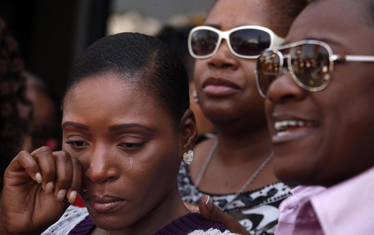 Maisha Allums, daughter of Marlene Pinnock, wipes away a tear at a news conference Thursday as attorney Caree Harper, right, discusses her mother's altercation with a CHP officer.
