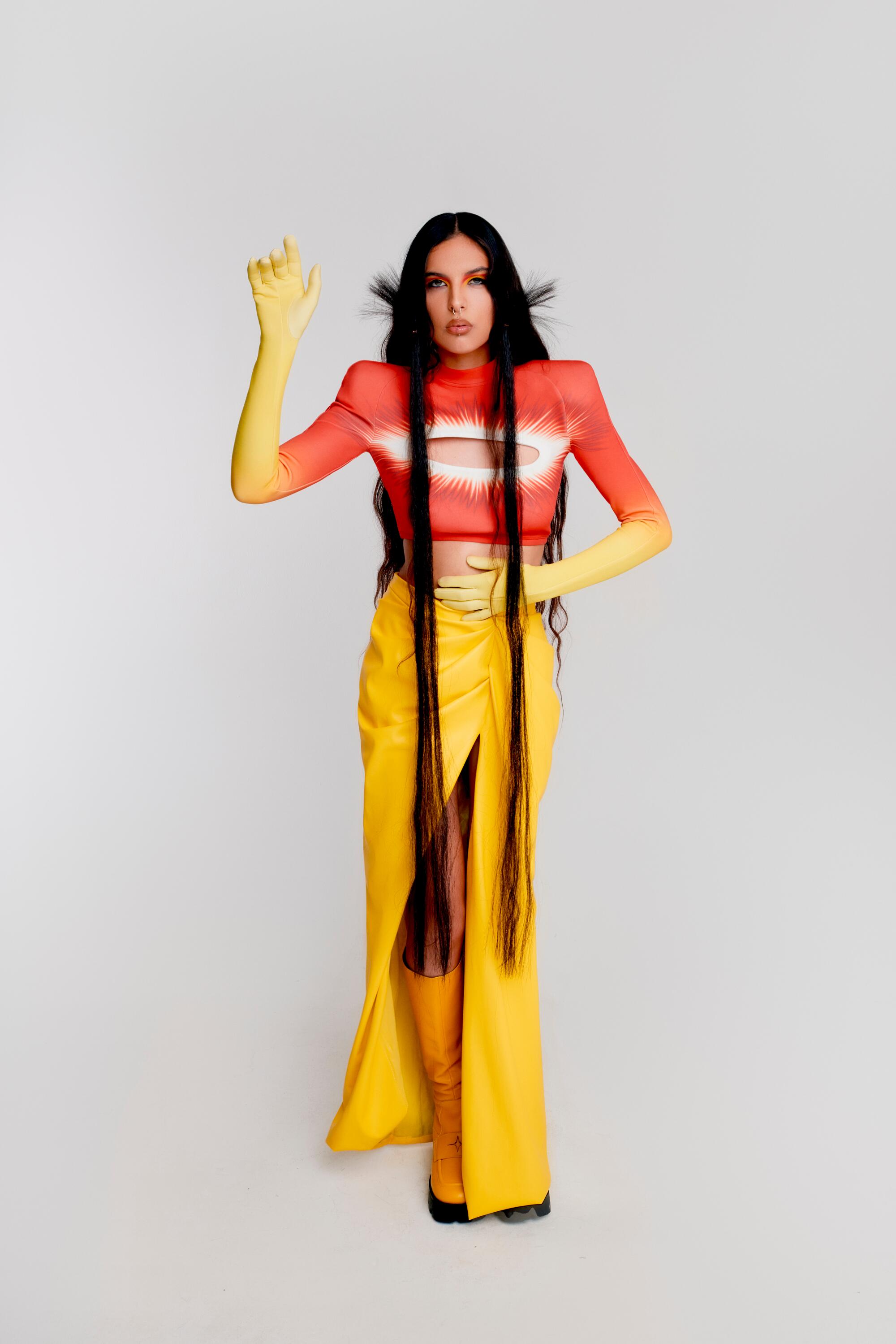 A woman wearings a red and yellow outfit, evoking the sun.