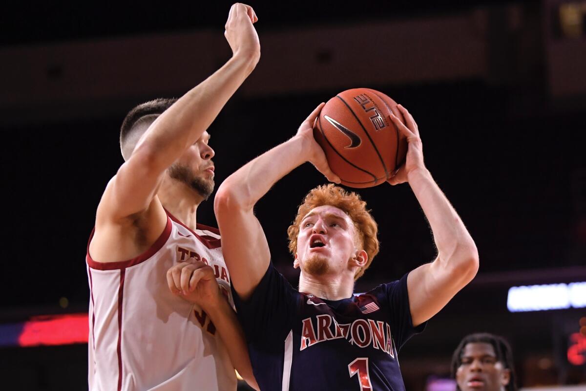 Arizona guard Nico Mannion, right, shoots as USC forward Nick Rakocevic defends during the second half on Thursday at Galen Center.