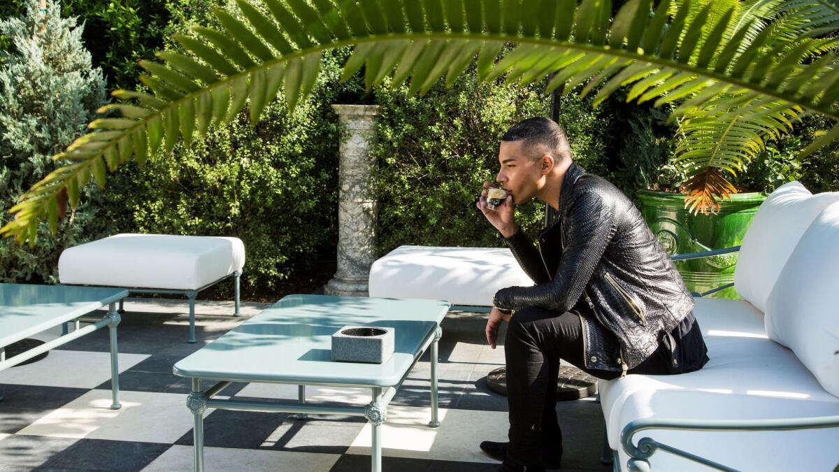 Rousteing taking a break in the outside garden at Balmain's new flagship store in Los Angeles. (Ricardo DeAratanha / Los Angeles Times)