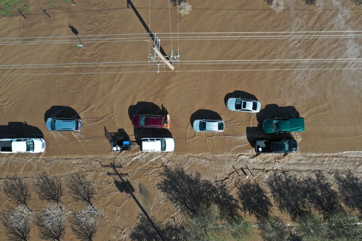 Aerial view of vehicles on a flooded road.