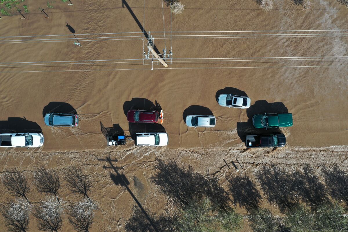 Cars detour on flooded Road 144 as both sides of Highway 99 closed due to major flooding in Earlimart in Tulare County.