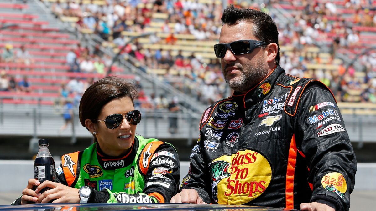 Danica Patrick, left, and Tony Stewart ride down pit road before the start of a NASCAR Sprint Cup Series race at Michigan International Speedway in June.
