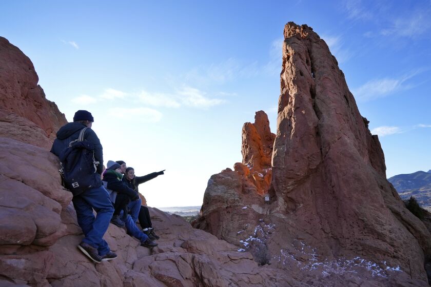 Varios excursionistas hacen una pausa para disfrutar la vista el miércoles 23 de noviembre de 2022, en Colorado Springs, Colorado. (AP Foto/Brittany Peterson)