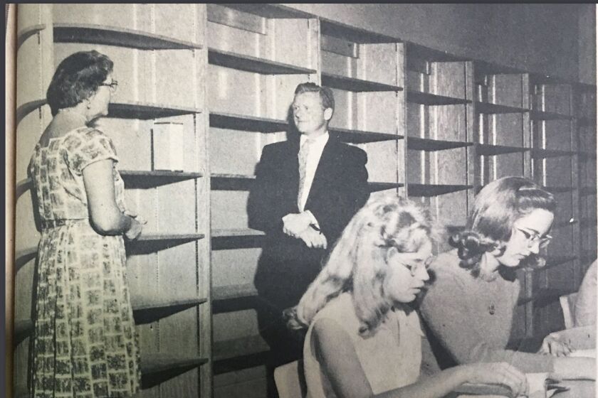 The caption for this 1961 newspaper photo said “EMPTY SHELVES symbolize the need at new Poway High School’s library for books. Standing are Mrs. Dave Shepardson, chairman Parents Club library committee, and Peter Hartmus, school librarian. Students in foreground are Cynthia White and Mary Shepardson. - Pat Kirkpatrick photo”