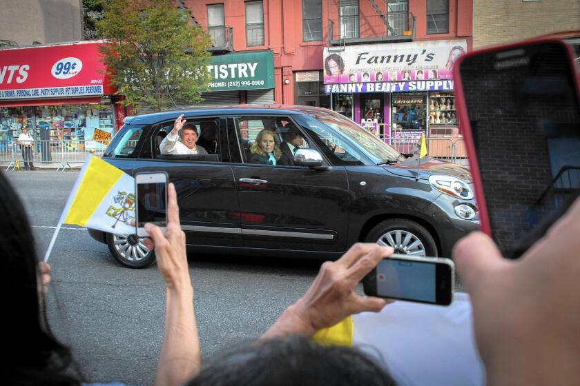 Pope Francis waves from the back seat of a Fiat during his visit to New York. The symbolism of the simple car resonated as powerfully as any of his speeches.
