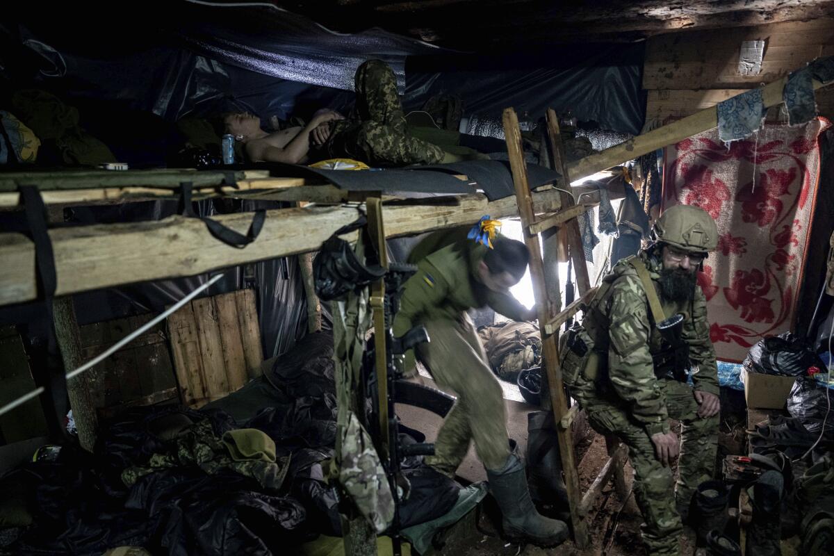 Ukrainian paratroopers rest inside a dugout 