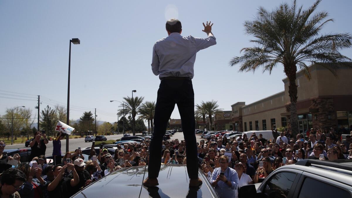 Beto O'Rourke speaks from the roof of his car to an overflow crowd at a campaign stop at a coffee shop Sunday in Las Vegas.