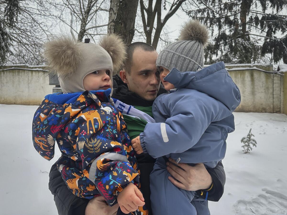 Tras un intercambio de prisioneros, Artem Dmytryk abraza a su hijo Timur, de dos años (derecha), 