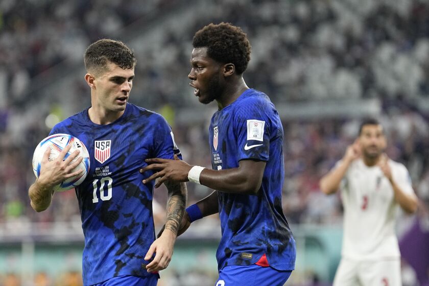 Christian Pulisic of the United States, left, and Yunus Musah of the United States speak before a free kick during the World Cup group B soccer match between Iran and the United States at the Al Thumama Stadium in Doha, Qatar, Tuesday, Nov. 29, 2022. (AP Photo/Ebrahim Noroozi)