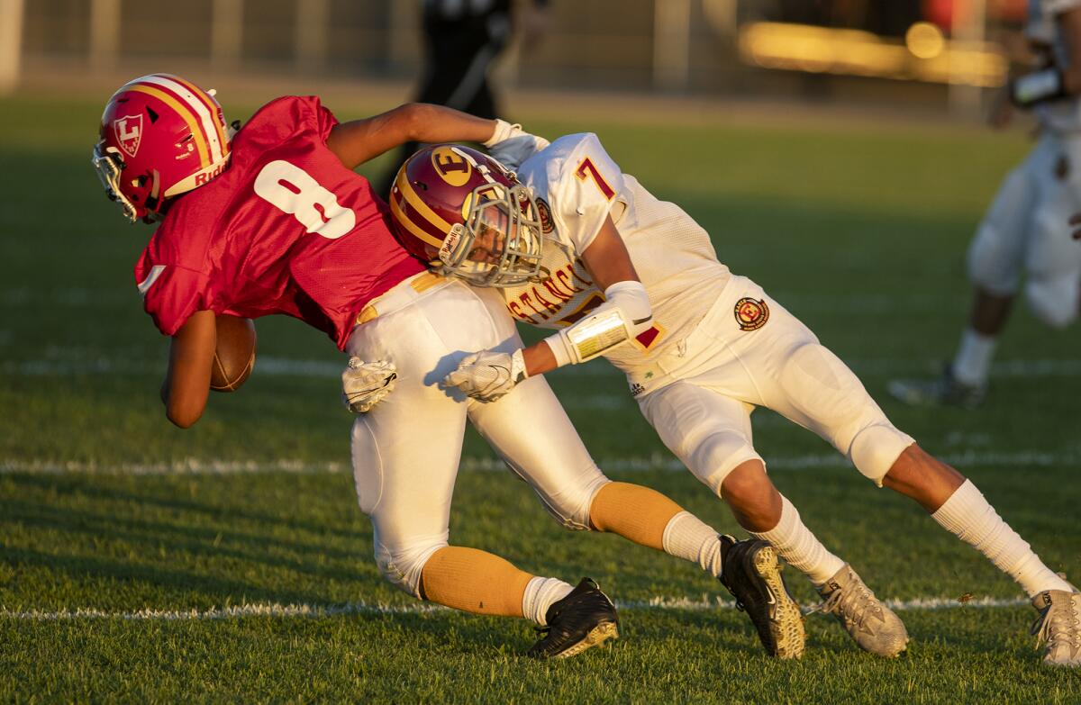 Estancia's Elijah Montoya tackles Loara's Preston Lopez (7) in a nonleague game at Western High in Anaheim on Aug. 29.