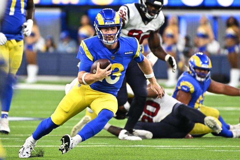 Rams quarterback John Wolford scrambles to pick up a first-quarter first down against the Texans on Aug. 18, 2022.