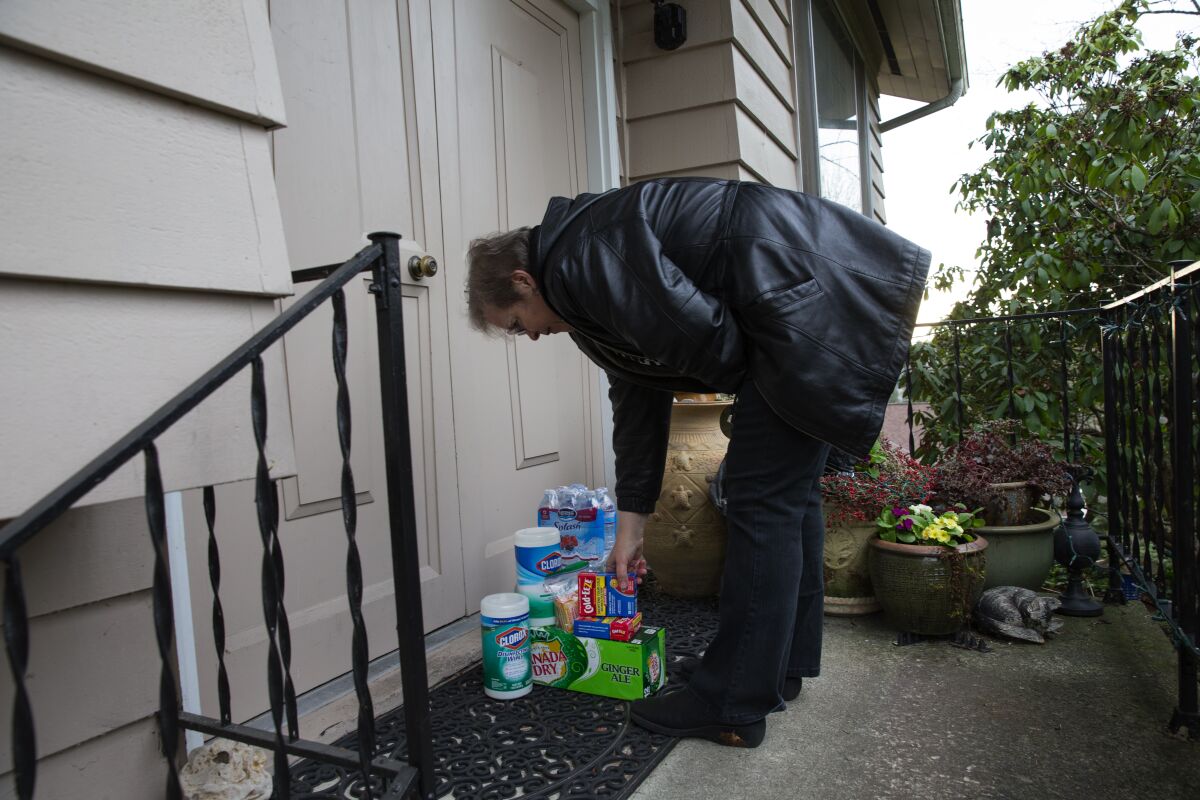 Cheri Chandler drops off disinfectants, throat lozenges and ginger ale for her parents, Pat and Bob McCauley, who are self-quarantined at their home in Kirkland, Wash., on March 10, 2020.